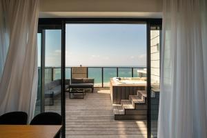 balcón con vistas al océano desde una habitación de hotel en YalaRent sea-breeze penthouse with jacuzzi, en Bat Yam