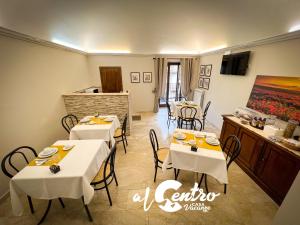 a restaurant with white tables and chairs in a room at Al Centro Casa Vacanze in Mistretta