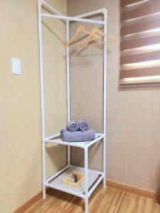 - une étagère blanche avec des serviettes dans la chambre dans l'établissement TreehouseUnseo GuestHouse, à Incheon