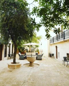 a courtyard with a fountain and chairs and a tree at Kaliruha Boutique Hotel in Urfa