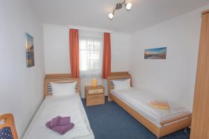Habitación con 2 camas y ventana en Ferienhaus zum Südstrand en Ostseebad Sellin