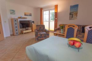 a living room with a table with a bowl of fruit on it at Ferienhaus zum Südstrand in Ostseebad Sellin