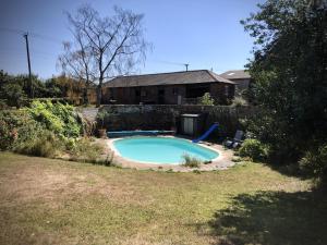 a swimming pool in the yard of a house at The Stables in Canterbury