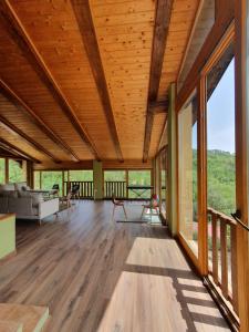 una sala de estar con techos de madera y ventanas grandes. en Masia La Clariana, en Castelltallat