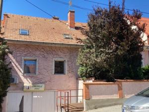 a house with a white fence in front of it at Peregrino Vendégház in Budaörs