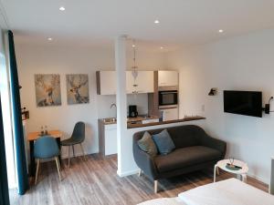 a living room with a couch and a kitchen at Gasthof Zumdohme in Lastrup