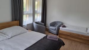 1 dormitorio con 1 cama, 1 silla y 1 ventana en Apartmány Mlýnská, en Horní Maršov