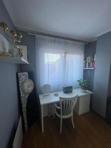 een bureau en een stoel in een kamer met een raam bij Habitación Bimba y Lolo in Ribadumia