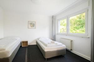 um quarto com 2 camas e uma janela em RAJ Living - 3 Room Apartments with Garden - 20 Min Messe DUS & Airport DUS em Meerbusch