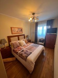 a bedroom with a large bed and a chandelier at Habitación Bimba y Lolo in Ribadumia