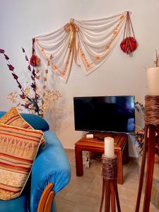 uma sala de estar com um sofá azul e uma televisão em Petra Maisonettes em Kariá