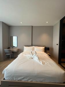 a bedroom with a bed with a white ribbon on it at Edge Central Pattaya Condo หรูใจกลางเมืองพัทยา in Pattaya Central