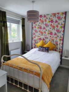 a bedroom with a bed with a floral wallpaper at Station House in St Austell