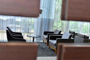 une salle d'attente avec des canapés et des chaises ainsi qu'une grande fenêtre dans l'établissement Ubumwe Grande Hotel, à Kigali