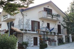 a large white house with balconies and trees at Agriturismo Montupoli in Miglianico