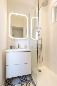 a white bathroom with a sink and a shower at Le Chapeau Rouge au coeur du centre historique in Avignon