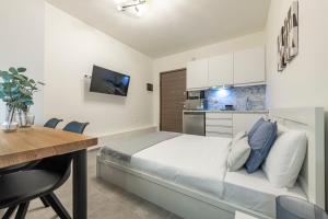 um quarto com uma cama, uma mesa e uma cozinha em Phaedrus Living: City Center Executive Flat Stadiou em Atenas