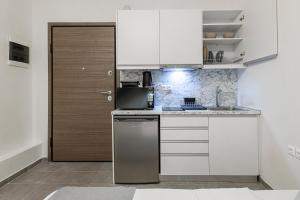 a kitchen with white cabinets and a refrigerator at Phaedrus Living: City Center Executive Flat Stadiou in Athens
