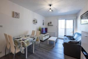 a living room with a table and a couch at Vacances a deux pas de la plage pour quatre personnes in Plage-des-Demoiselles