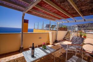 un patio con mesa, sillas y el océano en Penthouse La Palmita - Tazacorte, La Palma, en Tazacorte