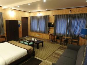 Kurseong的住宿－Nirvana Retreat，一间卧室配有一张床、一张沙发和一张桌子