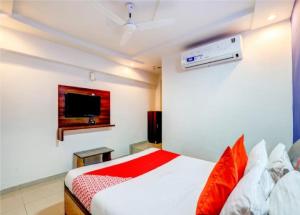 1 dormitorio con 1 cama y TV en Hotel Sangam en Ahmedabad