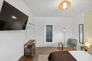 a bedroom with a bed and a tv on the wall at Charysma - Chillout-Loft, Wintergarten, E-Kamin, Massage-Sessel, Schlafzimmer mit Smart-TV, 2 Parkplätze in Hameln