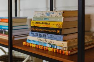 una pila de libros sentados en un estante en Dom pod Klonem, en Jantar