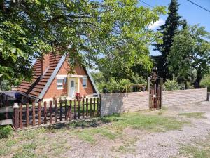 a house with a wooden fence and a gate at Kuća za odmor Apathy in Opatovac