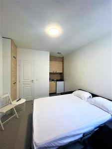 1 dormitorio con 1 cama blanca grande y 1 silla en Les Halles Appartements, en París
