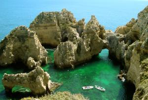un grupo de rocas en el agua con dos barcos en Lagos City Center Guest House & Hostel, en Lagos