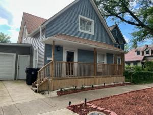 a blue house with a large deck with a porch at Uber Close to Ohio City, Cleveland (Lower) in Cleveland