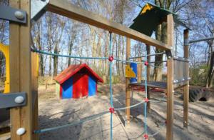 a playground with a toy house and a swing at Bernsteinreiter Erlebnishof Barth, Blockhütte 20 in Barth