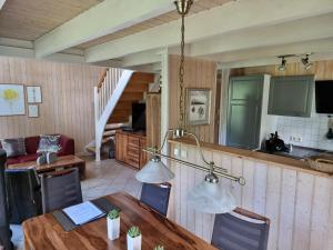 a kitchen and dining room with a table and lights at Haus Sandra in Baabe