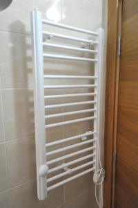um radiador branco numa casa de banho ao lado de um chuveiro em Kopaonik Apartman Sanja em Kopaonik