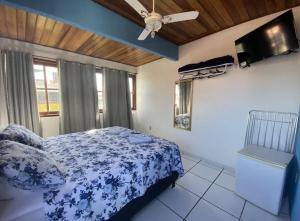 1 dormitorio con 1 cama y ventilador de techo en Pousada Azul do Mar, en Arraial do Cabo