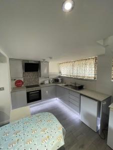 a kitchen with white cabinets and a bed in it at Magnolia Passageway to the Jurassic Coast. in Stoborough