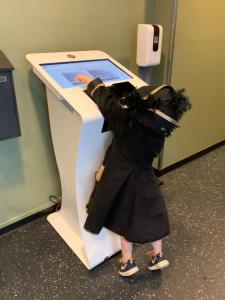 een klein meisje in een kostuum die naar een tablet kijkt bij Citybox Lite Kristiansand in Kristiansand