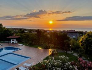 a villa with a swimming pool and a sunset at Villa Anna in Leptokarya