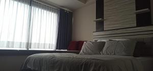 KejayanにあるRuby Apartment #10のベッドと大きな窓のある寝室