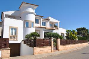 a white house with a fence at Villa Teresa in Colonia Sant Jordi