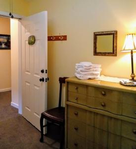 a bedroom with a dresser and a lamp and a mirror at Laughing Heart Lodge in Hot Springs