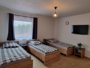 een kamer met 2 bedden en een flatscreen-tv bij Pokoje pod Wietrznią in Kielce
