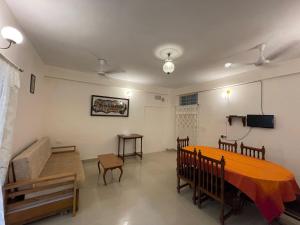 un soggiorno con tavolo e divano di Homestay a Varanasi