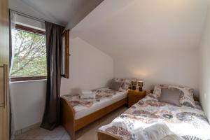two beds in a room with a window at House Villa Mira in Trogir