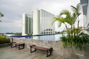 two benches sitting on a balcony with a building at Ruby Apartment #9 in Yogyakarta