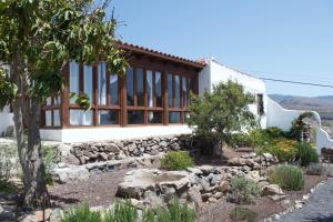 聖地亞哥海灘的住宿－Casa Los Llanos，一座带大窗户和石墙的房子