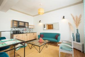 Hasambarana Apparthotel في أنتاناناريفو: غرفة معيشة مع أريكة زرقاء وطاولة