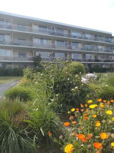 an apartment building with flowers in front of it at Joy Lotus 105 in De Haan