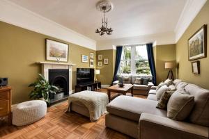 ein Wohnzimmer mit einem Sofa und einem Kamin in der Unterkunft 8b Howard Place in St Andrews